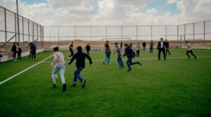 Children play on a new sports field in Halutza